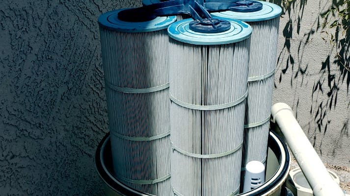 Pool technician cleaning a cartridge pool filter system
