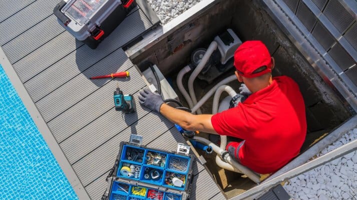 Pool technician performing repair on backyard pool equipment in Scottsdale AZ