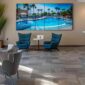 a sleek, modern office reception area in scottsdale showcases a vibrant digital display featuring various pool service options, with professional staff engaging warmly with clients in a polished, inviting environment.